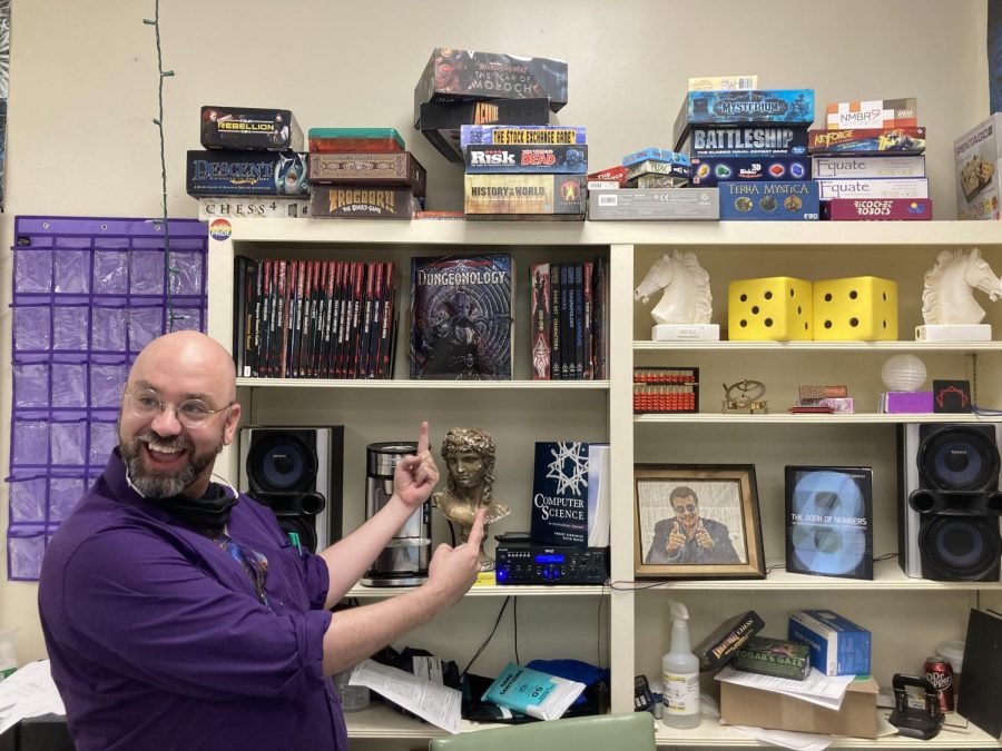 Mr.+Mills+shows+a+group+of+Board+Game+Club+students+the+different+character+classes+they+can+be+in+a+game+of+Dungeons+and+Dragons%2C+helping+the+first-time+players+set+up+their+characters+the+way+they+want+them.+%E2%80%9CI+love+sponsoring+the+club+because+I+get+to+share+my+love+for+tabletop+board+games%2C%E2%80%9D+Mills+said.+%E2%80%9CIf+we%E2%80%99re+doing+DnD+I+get+kids+who+are+really+more+in+their+shells%2C+and+this+is+their+social+outlet.+Naturally%2C+they%E2%80%99re+really+shy%2C+but+they+get+to+open+up+through+the+experience+of+role-playing+games.+They+get+to+be+whoever+they+want.%C2%A8%0A