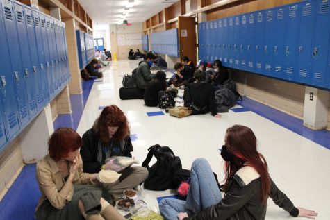 students sitting in a hallway