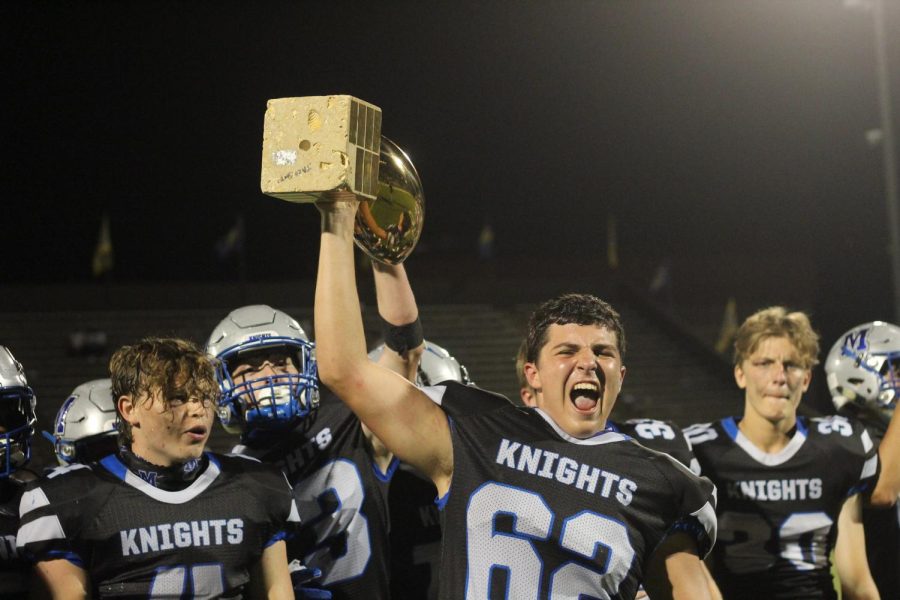 Center Braeden Price holds up the Taco Shack Bowl trophy, after they defeated Anderson for the first time since 2018.