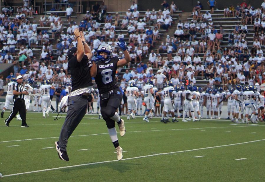 Brock Fanning celebrates with his defensive coordinator after he intercepts the ball against Anderson in the Taco Shack Bowl.