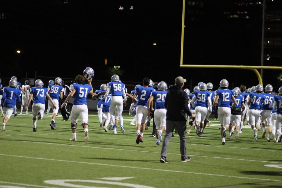 The McCallum sideline rushes the field after the Knights took down Glenn in overtime.