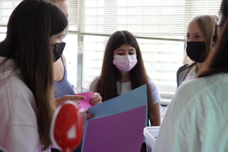 In this photo, 3 Key Club members are creating a card. 
