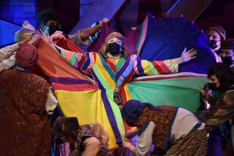 JUMPING AROUND : As sophomore Finn Griffith (Joseph) performs “Joseph’s Coat,” Marshall Clifton (front and center) plays Gad, one of Joseph’s brothers. who holds up the coat during the song. Clifton’s role as a swing was to step in to perform if any actors were missing. “Getting this opportunity to hop in and out of different roles was amazing,” Clifton said. Joseph was his third musical. “I’m pretty new to musical theatre,” they said. ”While this was definitely a lot of work, I am so glad I [had] this opportunity.” Reporting by Cassidy Levin.