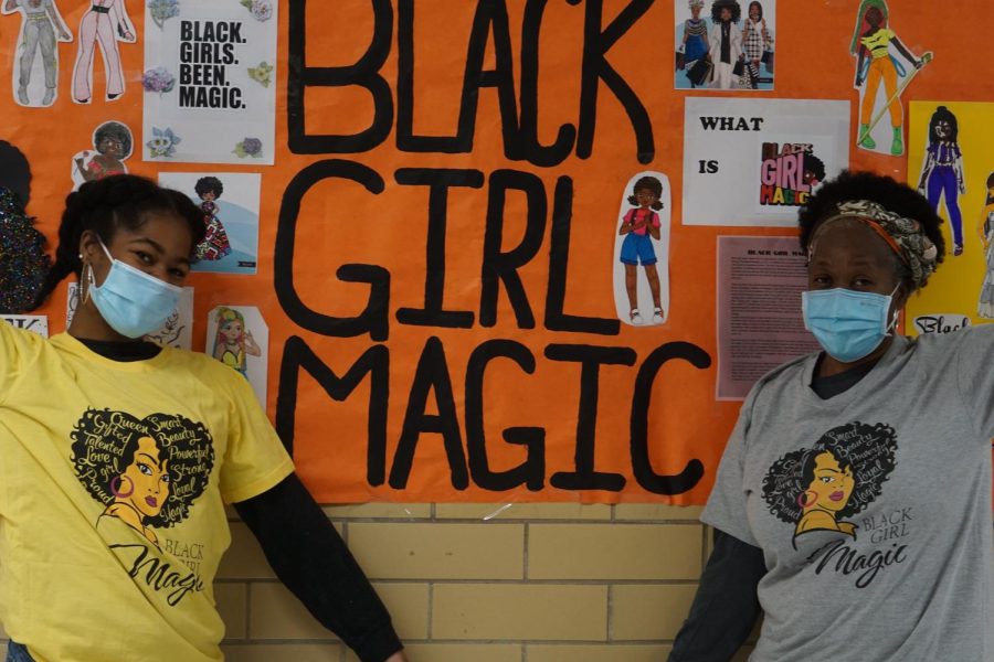 Senior Ashley Nicely and Fine Arts Academy clerk Tonya Moore pose in the Black Girl Magic contest T-shirts in front of the Black Girl Magic poster in the main hallway. The poster featured artwork created by students about what the Black Girl Magic movement means to them. On Feb. 17, junior Regan Sims and sophomore Jendayi Innocent were named the winner and the runner up in the contest. Black girl magic is so important because we have to teach our kids that theyre beautiful no matter what skin tone they are, Moore said.