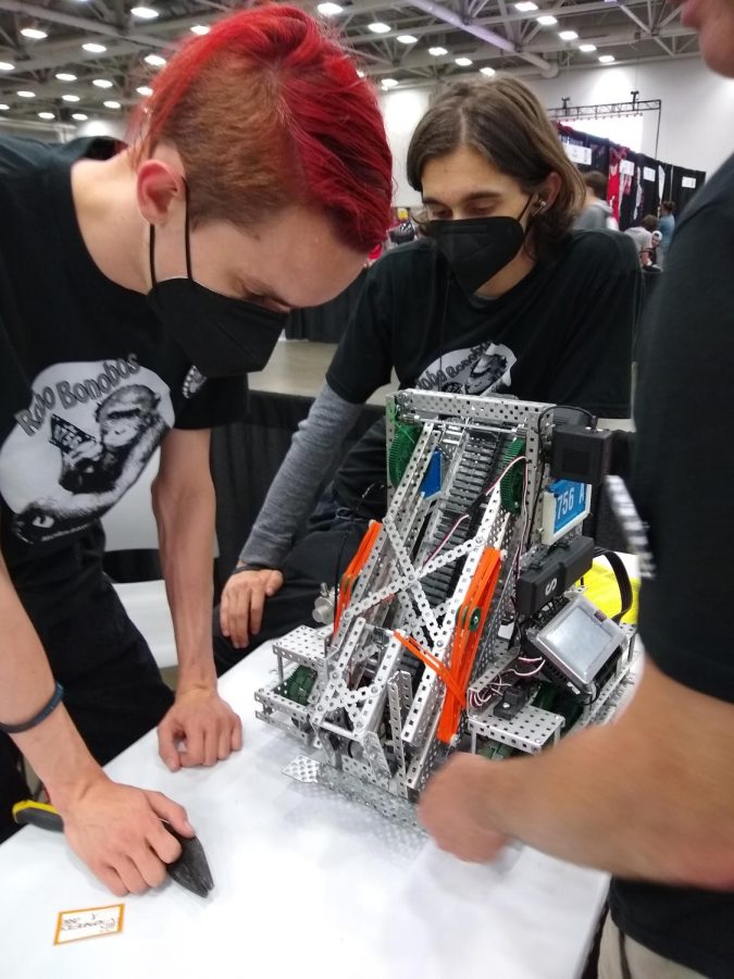 At+the+VEX+Robotics+World+Championship+in+Dallas+on+May+6%2C+senior+Miles+Bourgeois+inspects+the+teams+robot%2C+Mecha+Kanzi+2000.+Bourgeious+and+his+teammates%2C+seniors+Ava+Carlson+and+Carson+Pallotta+and+junior+Evan+Henderson%2C+became+the+first+Mac+robotics+team+in+more+than+a+decade+to+qualify+for+Worlds.+Bourgeois+attributed+their+success+to+their+ability+to+work+together.+We+were+all+kind+of+on+the+same+wavelength%2C+and+we+trusted+each+other.+That%E2%80%99s+the+biggest+thing.%E2%80%9D