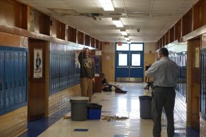 While Fine Arts Academy director Gabe Reyes inspects the damage last April, then senior William Benson points to an all-to-common Mac malady: a water leak, this one outside of history teacher Clifford Stanchoss classroom.