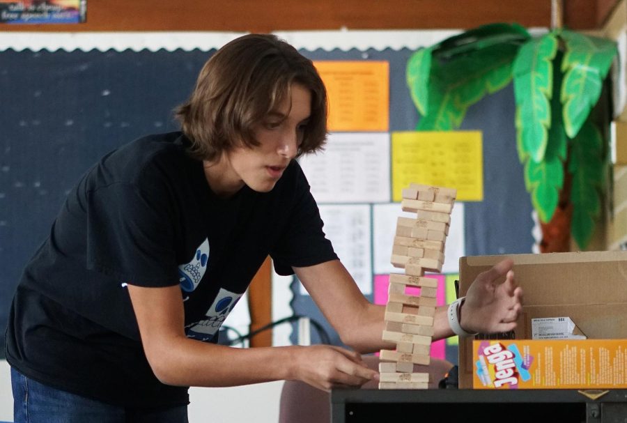 BACK FOR SECONDS: Sophomore Kyan Adams participated in digital media teacher Dave Winter’s ice breaker activity during third period on the first day of school. Attached to each Jenga block was a mailing label with a different icebreaker question on it. Students pulled a block off the tower and then read and answered the question. For Adams the activity provided a nice change of pace from the normal icebreakers that day. “It was fun, it was different, Adams said. Ive never seen an icebreaker with Jenga.” Adams went first in the class and successfully replaced his block atop the tower, but when his team was a player short, he volunteered to take a second turn which did not end quite as well as his initial effort. Caption by Naomi Di-Capua.