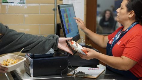 Cafeteria worker Daisy Miranda rings up a student coming through the lunch line.