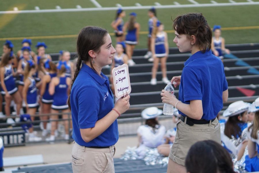 Drum majors junior Sofia Hamlet and sophomore Bea Saffer help lead the marching band during warm-ups before the Connally game on Sept. 8. 