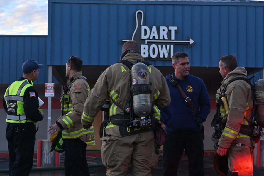 Firefighters gather in the Dart Bowl parking lot on Wednesday afternoon. After extinguishing the fire inside, they ventilated the building so the smoke could dissipate. An investigation to determine the parties responsible for the fire is underway and brought firefighters to McCallum on Thursday.