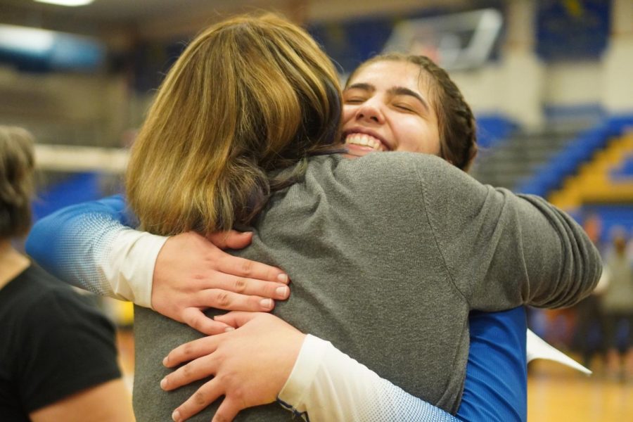 RIGBY RETURNS: She may not work at McCallum anymore but former special education department chair Julie Rigby remains a huge supporter of Mac volleyball. After making the trip to Pflugerville for the bi-district playoff match between the Knights and Panthers, Rigby offers a huge hug to senior outside hitter Jette Morris. Photo by Dave Winter.