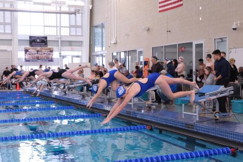Sophomore London Pangini and freshman Iris LaRue dive into the water at the start of the Girls 100 Meters Breaststroke race. Pangini placed 12th and LaRue placed 11th. 