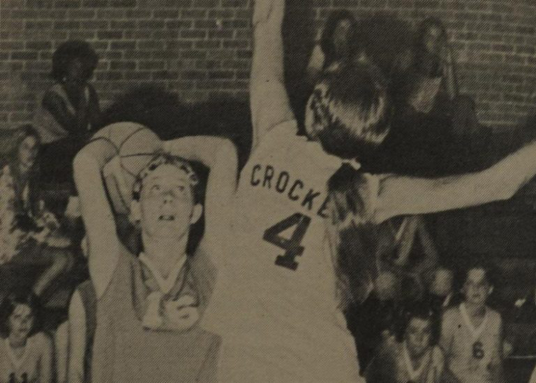 Sighting her target, center Tina Powers, attempts to shoot over a jumping Crockett Cougar. The consistent scoring cager made good of this attempt and helped the Knights to an overwhelming 52-28 victory. Photo was originally published in the Oct. 17, 1974 issue of The Shield.