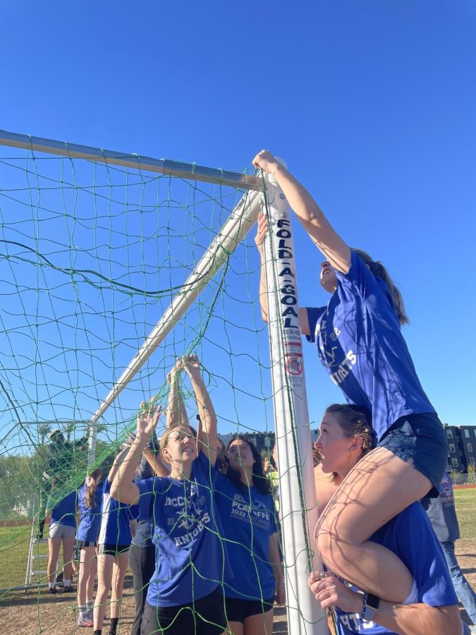 SHOOTING FOR THE STARS: On the first day of soccer tryouts; Chloe Anderson, Caroline Owen, Esme Moreno and Emmi Anderson are seen setting up McCallums new soccer nets. The McCallum Knights soccer team have gone without nets in their goals for the first couple months of practicing together, Monday was the start of the knights’ tryouts that continued the rest of the week. “It’s an advantage to be able to fully play on the field, without having to chase after the balls,” Priya Thoppil said.  “Basketball players don't play basketball without a hoop, so soccer players shouldn’t have to play on goals without nets.” 4ATX, a non-profit organization dedicated to “Using the power of soccer to help communities thrive'' donated the green soccer nets to McCallum soccer program, “Often times when we talk about making soccer more accessible to everyone, we overlook a basic detail: access to basic equipment.” says Katlin Mauro, 4ATX Executive Director in Austin FC’s recent news story.  The foundation is run by Austin FC, seeking to close the opportunity gap and create Austin's next generation of leaders. We are continuously grateful for this donation, and hope to put these soccer nets to good use. GO KNIGHTS!