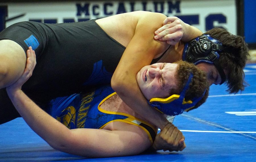 EXCEDRIN HEADLOCK: McCallum may have lost decisively to Anderson in its opening wrestling match of the season, but there were some highlights to build on. Winning his match by pin, senior Corgan Berger said he was able to overcome his emotions and enjoy success.

“I fought and I never gave up,” Berger said. “I went into the match, and I was terrified, but its not about being afraid: its about what you do when you are afraid.”

Although Berger walked away with a win, he felt that he could have left more on the mat. 

“I think I couldve done a little bit better.” Berger said. ”I mean, some might say if you look at the scoreboard it was 11-4 some might say I was ‘killing it,’ but personally I think that there were a few things that I couldve done better.” Photo by Lillian Gray.