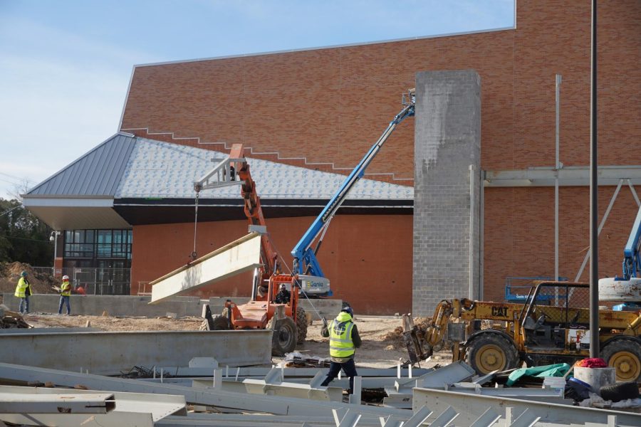 Construction crews lift beams to build the framework for the new dance studio on Feb. 17. Since, construction for the studios exterior has progressed, and the dance teachers have begun ordering everything from shelves to paints in preparation for its opening next spring.