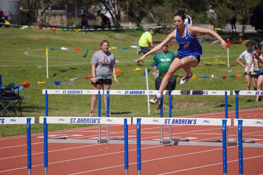 Sophomore Gabriele Rodriguez leaps over a hurdle in the 100 meter event. Rodriguez took home the gold in JV 100 and 300 meter hurdles.