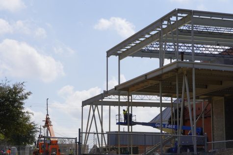 A lone worker tugs on a segment of rope atop a boom lift on March 10 while the dance studio’s metal framing looms above. Since, construction for the studios exterior has progressed, and the dance teachers have begun ordering everything from shelves to paints in preparation for its opening next spring.