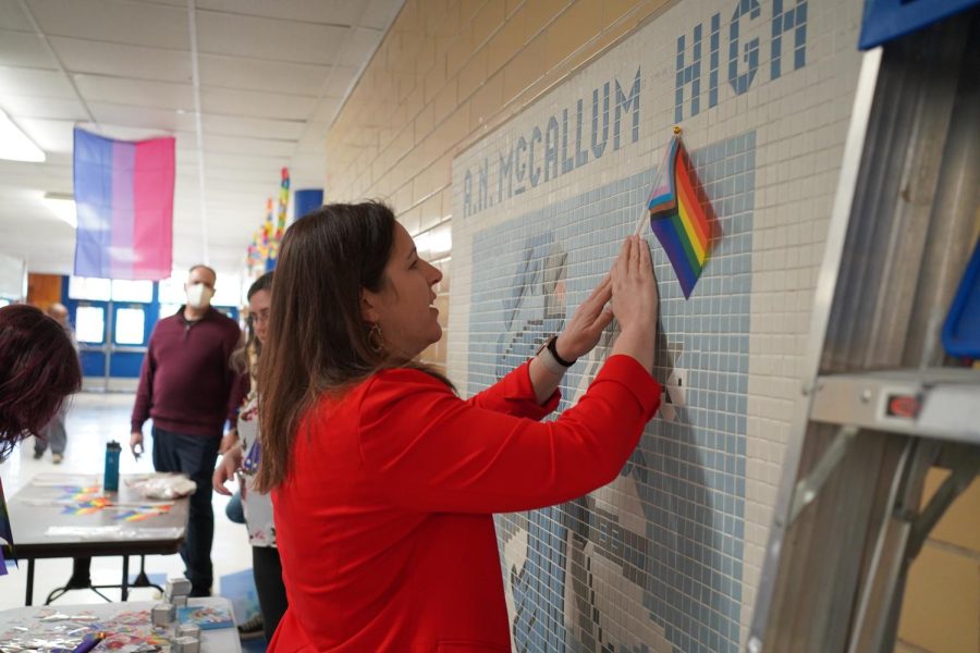 YEAR ROUND PRIDE: Principal Nicole Griffith fixes a pride flag to the Knight mural in the main hallway. Though the official PRIDE Month is not until June, AISD has hosted a PRIDE Week during the school year since 2014.

“I know that this isn’t when everyone else celebrates PRIDE, but I love that AISD takes a moment in the year to celebrate,”  Griffith said. “We can’t celebrate during the summer because all of our students are here, so taking that extra step so we can have that PRIDE Week where we validate and celebrate and empower students and staff and their families to feel that there is a place for them here is really important.”

Griffith compared the current environment favorable to her experience as a student growing up in a less tolerant age where it was much harder to LBBTQ+ students to be visible and free to express themselves.

“This whole generation is so much more accepting,” Griffith said. “As an educator, I think back to my own time as a middle and high school student, and there was zero representation and certainly no representation so to be able to see young people embrace diversity is really refreshing because that is not the world I grew up in.” 

Caption by Morgan Eye. Photo by Dave Winter.