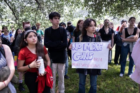 ENOUGH IS ENOUGH: Freshman Sophia Arredondo, pictured above in red, attended the walkout protest after first hearing about it from a friend. She supported the ideas but wasn’t exactly sure what to expect.
 “I have to admit I was pretty nervous because it was my first time going to a walkout but at the same time I was excited seeing people getting together. it’s really amazing.”
Arredondo appreciated the symbolic significance of the actions at the walkout. “One of the things that I did during the walkout was lay on my back. we all lied down to show our respect to the people that have died due to gun violence. We also listened to Teddy Ibsen explain why we were there and why guns are a continuing problem in our area. I remember her saying Enough is enough We need to end this now and Am I next? It was really powerful to hear.” Arredondo thought that the walkout was positive and effective in sharing a message. “I wish other people could see and hear that the use of guns are so bad. They are effecting us to the point where we had to get together as a community and speak up.” Caption by Lucas Walker. Photo by Gergő Major. 