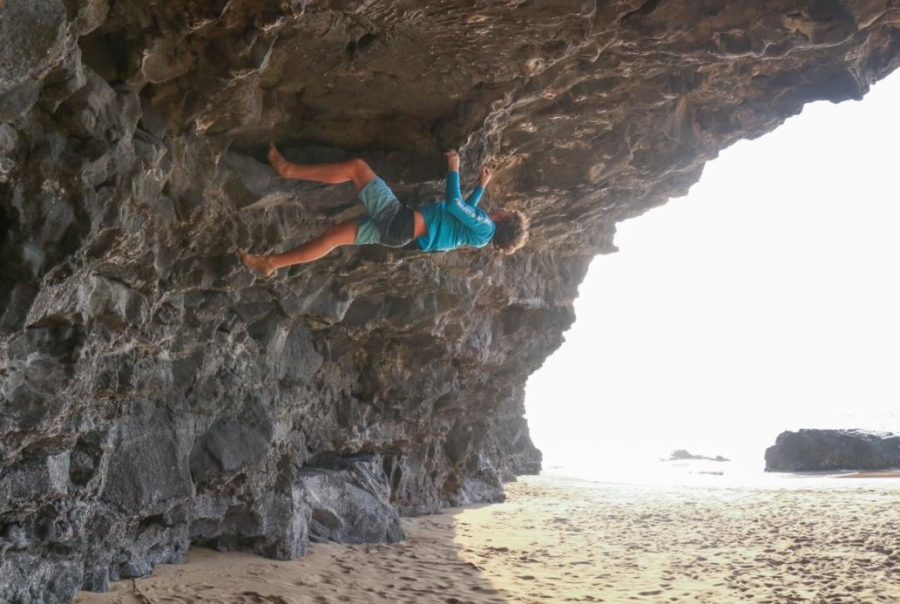 Senior Ethan Kuhlken hangs from a rock during a party on a beach in Hawaii. I had wandered onto the beach and found a cave in the rock, Kuhlken said. I got a very strong urge to climb up the edge so I just started looking at my route and climbing. I felt very free and it was liberating, but it was so unsafe. 