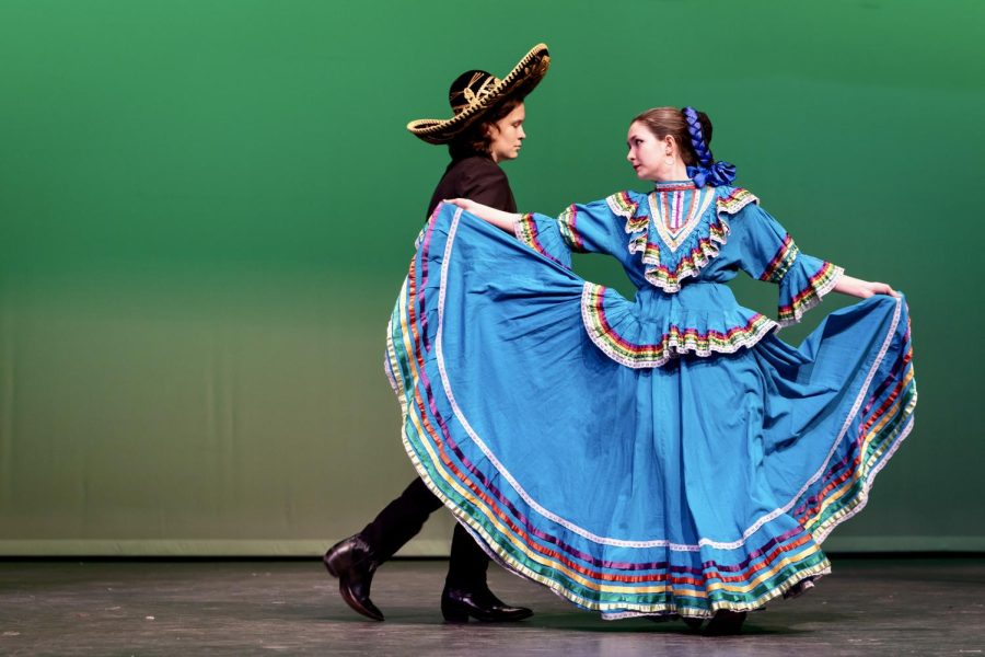 ASSERTING MEXICAN IDENTITY: Freshman Abigail Peacock and sophomore Maverick Palacios perform the first Ballet Folklórico dance of the Cinco de Mayo show. The dance, called “Jarabe Tapatío,” is also known as “The Mexican Hat Dance.” Peacock joined Ballet Folklórico because she wanted to try something she hasn’t done before. “I saw them perform a number of times when I was in elementary school,” Peacock said. “I always admired the dancers so much.” Peacock’s favorite part of the show was when she was able to bring friend Lila Cisneros-Wise on stage during the last dance.  “We got to bring people up on stage with us,” Peacock said. “It was fulfilling seeing everyone so excited and want to participate. Lila has always been enthusiastic about me dancing folklórico, and she is a really fun person, so I thought she’d be good to dance with.” Peacock felt that this show was important to embrace Mexican culture. “Cinco de Mayo helps Mexican Americans assert their identity while living in the U.S.,” Peacock said. “This particular celebration helped bring Mexican culture to McCallum.” Caption by Kate Boyle.