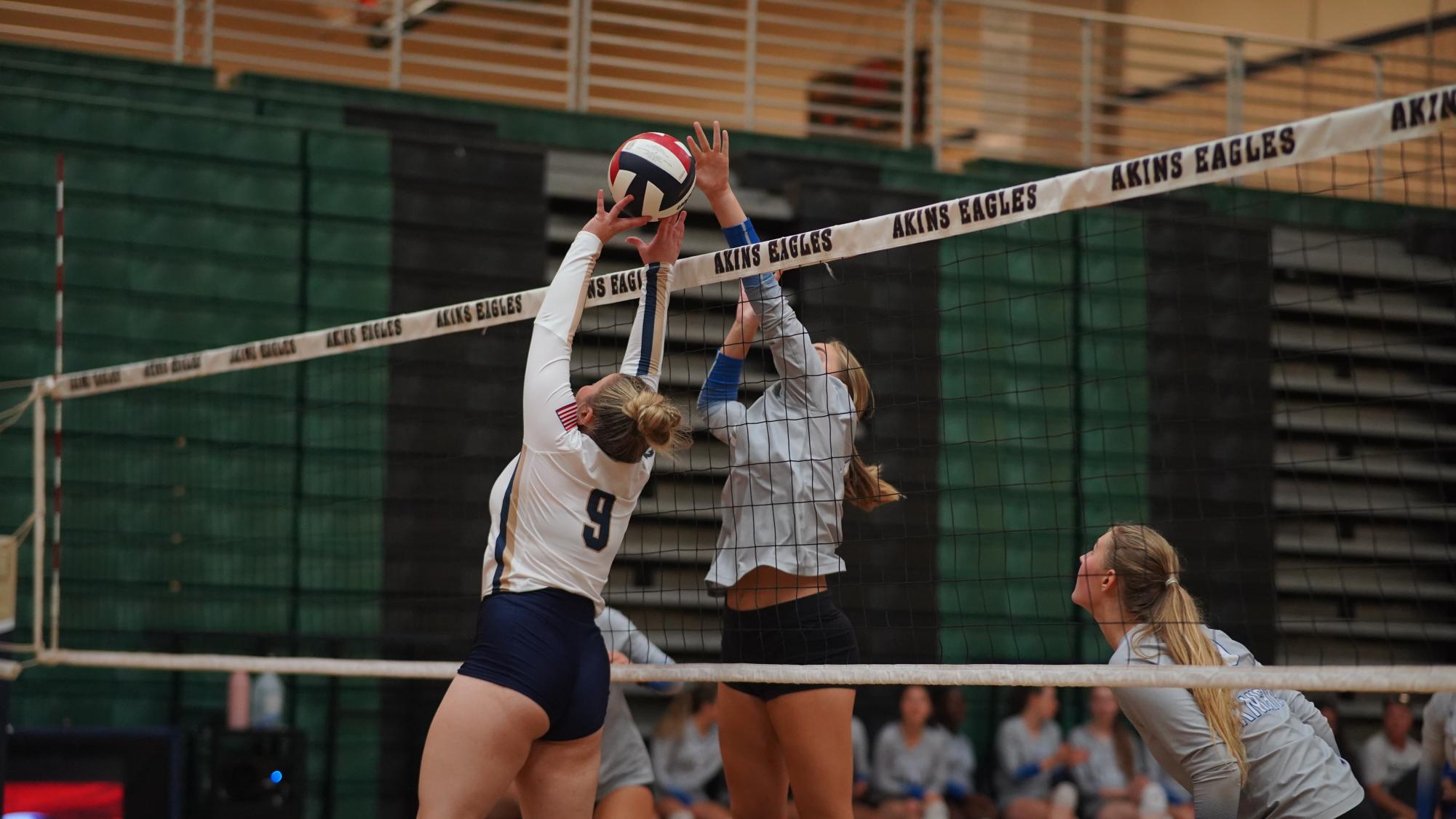 Senior middle blocker Cate Thoden extends to successfully block an Akins player from tipping the ball over the net during the varsity Knights straight-set sweep of the host Eagles last Tuesday night. [This game was] more of just a mind game, [to see] if we can keep our rhythm going and not just slow down because the other team might be slow, Thoden said. You have to expect the unexpected at all times. You’ve got to push through.