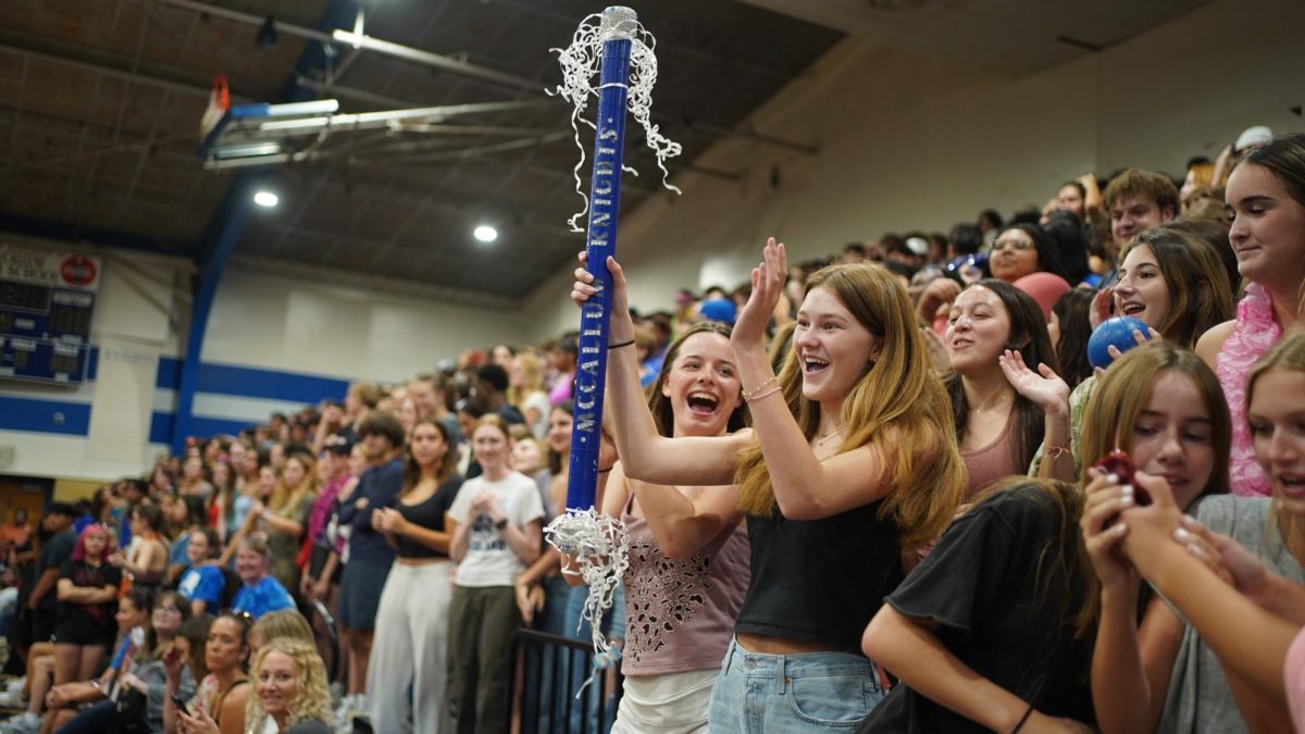 SENIORS GOT SPIRIT: Senior Emmy Penders cheers after being awarded the spirit stick. Penders was given the stick after the senior section had the loudest chant at the pep rally. 
“I wasn’t shocked that the senior class won the spirit stick, but it was still exciting,” Penders said. “In the past two years I saw the seniors before win, so it was nice to finally win it for our class.”
Penders enjoyed the pep rally.
“The pep rally created a fun atmosphere that made me excited to attend the game,” Penders said. “My favorite part was chanting our senior battle cry and then popping the confetti, because it’s another fun tradition seniors get to do during senior year.”
Although Penders had a great time, she couldn’t help but feel a twinge of sadness.
“It’s bittersweet that this is my last year of pep rallies because I’ll miss the school spirit that happens during it,” Penders said. “But I’m also excited to move on to new experiences.”
Caption by JoJo Barnard. 
