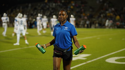 Junior Brianna Miller brings water to football players during a timeout