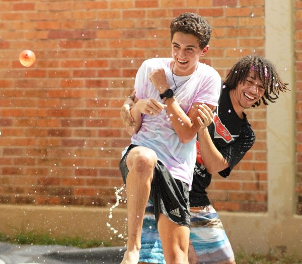 WATER BALLOONS AND SMILES: Senior Peer Assistance and Leadership program member Jude Masoni holds up his fellow PAL, senior David Herring, as a human shield to protect himself from the path of an incoming water balloon. Students paid $1 to throw a balloon at the PALS on Tuesday as part of the shooting PAL-ery, one of the Pink Week fundraisers intended to raise money for the Breast Cancer Resource Center of Central Texas, an Austin-based non-profit that provides personalized support to those affected by breast cancer.  Year after year the PALS put on Pink Week in order to raise funds and awareness for the fight against breast cancer. The PALS put on a variety of different events the whole week at lunch in hopes of both bringing in profits and bringing an exciting week of fun to the McCallum community.   

Herring was made a target of the water balloon by his cross country teammates.

“I enjoyed seeing my teammates coming out to donate as I was telling them about it the week prior,” Herring said. “I was also just having fun on that nice day with my fellow PALS. Some of them that did the pallery that day, like Jude, I’ve known since elementary school.”

Caption by Chloe Lewcock with reporting by JoJo Barnard.  