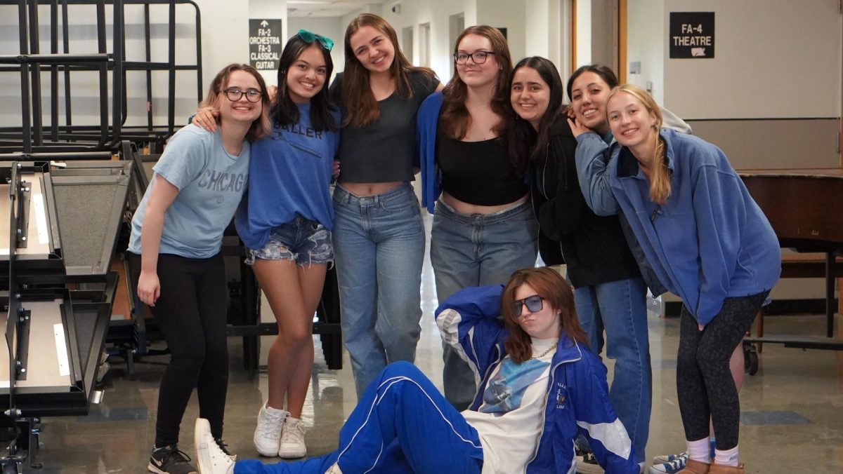 CREW OF BLUE: Seniors (left to right) Julia Lyon, Jaella Brush, Naomi Di-Capua, Alex Thomason, Roxie Satija, Spirit Smith and (floor) Clara McFadden pose for a photo during choir class to showcase their outfits for Thursday’s spirit day. Thursday was the day of the game, so the spirit day theme was school colors. Each class had a corresponding color: freshmen-white, sophomores-gray, juniors-black and seniors-blue. The annual tradition intrigued Smith.
“I was excited to see what grade would show the most spirit this year,” Smith said.
Smith views spirit days as a way for the school to come together.
“I enjoy spirit days because they give the student body a chance to be involved,” Smith said. “And there aren’t very many opportunities for our school to be involved in things as a whole.”
Caption by JoJo Barnard.
