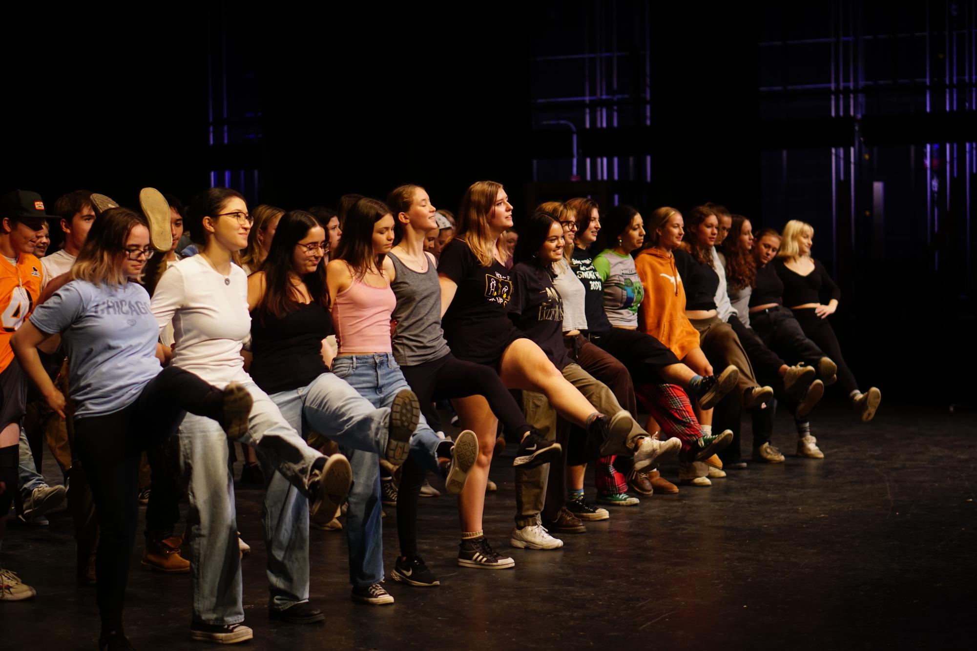 The cast of the choir’s annual “Cabaret” kick into action at choreography rehearsals on Nov. 12 in the McCallum Performing Arts Center. The members rehearse their musical number “A Musical” from the show Something Rotten. The production will open Thursday with evening shows on Friday and Saturday and a matinée finale on Sunday. One of the head choreographers, pictured in the center front row, Jaella Brush, faced challenges choreographing this number but overcame them with the help and flexibility of everyone participating. “It’s hard to know if something will look good in a big group until you do it,” Brush said. “Not every dance move is gonna look good or work with everyone’s vocal/dance abilities when you put it into action, so being able to think quickly and change it up sometimes has been important.” 
