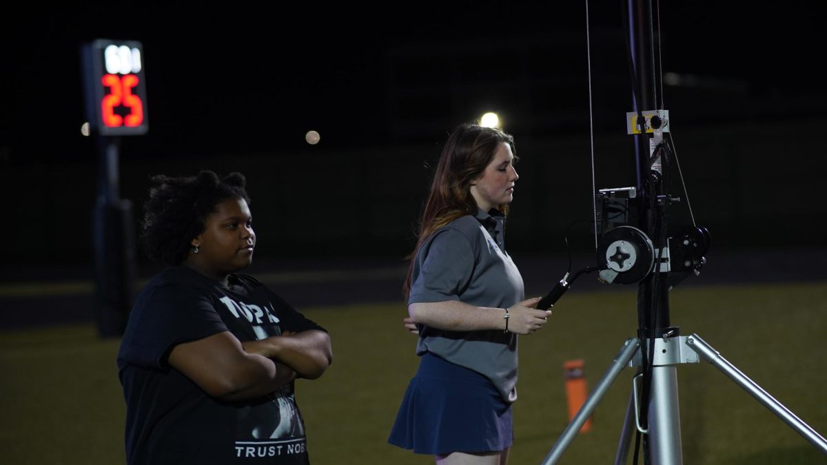 Film crew members freshman Shyla Manhart and junior Ivy Christie record a play  at the LASA game Oct. 13.