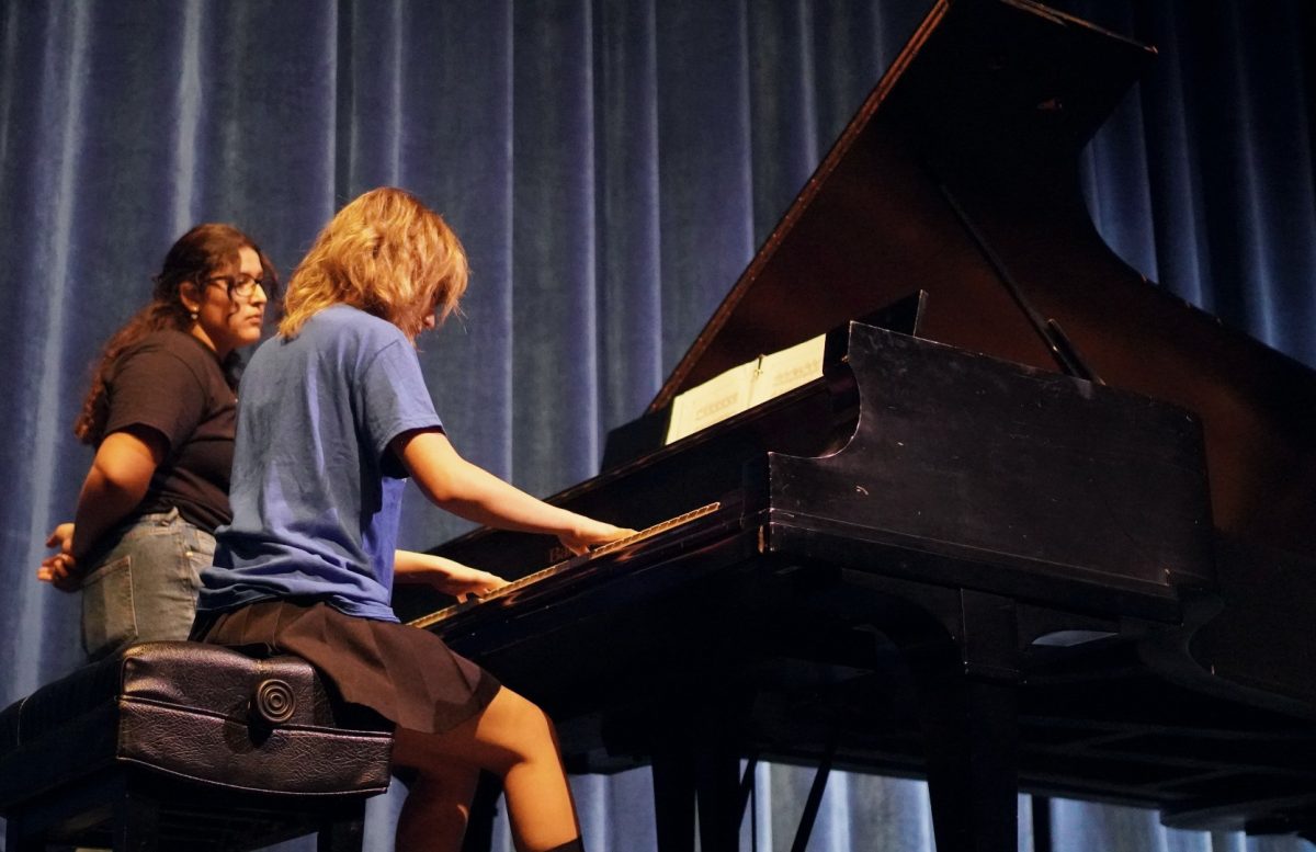SMALL BUT MIGHTY: Seniors Isa Aleman Ward, standing, and Isa Pirkey, seated, represent the piano program with the song Liszt Liebestraum No. 3 to show the current students and incoming middle-schoolers what the piano program has to offer. While it has the fewest number of majors of any academy program, all music majors take the piano class. Director Dr. Sam Parrott praised the piano majors for their focus on their craft.

Illustrating that focus, Pirkey said that she spent months on the piece. “Ive been working on it since February,” she said, adding that the long hours of practice are worth for performance opportunities like the showcase. She said she hoped here performance could motivate others to focus on piano study.

“I always look forward to playing for middle-schoolers and hopefully inspire them to join the fine art program.

Caption by Aubrey Macedo.