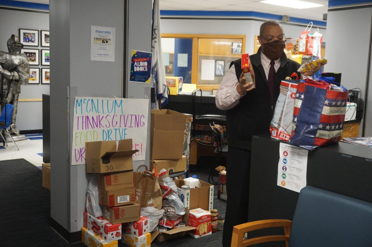 Mr. Featherstone standing next to the food donated to the thankgiving food drive