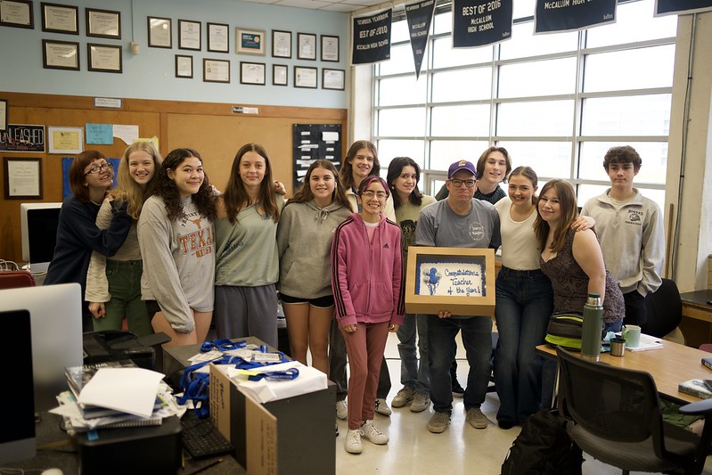 Teacher of the year, Dave Winter, poses with his celebration cake surrounded by his newspaper staff and digital media students who were present for the surprise.