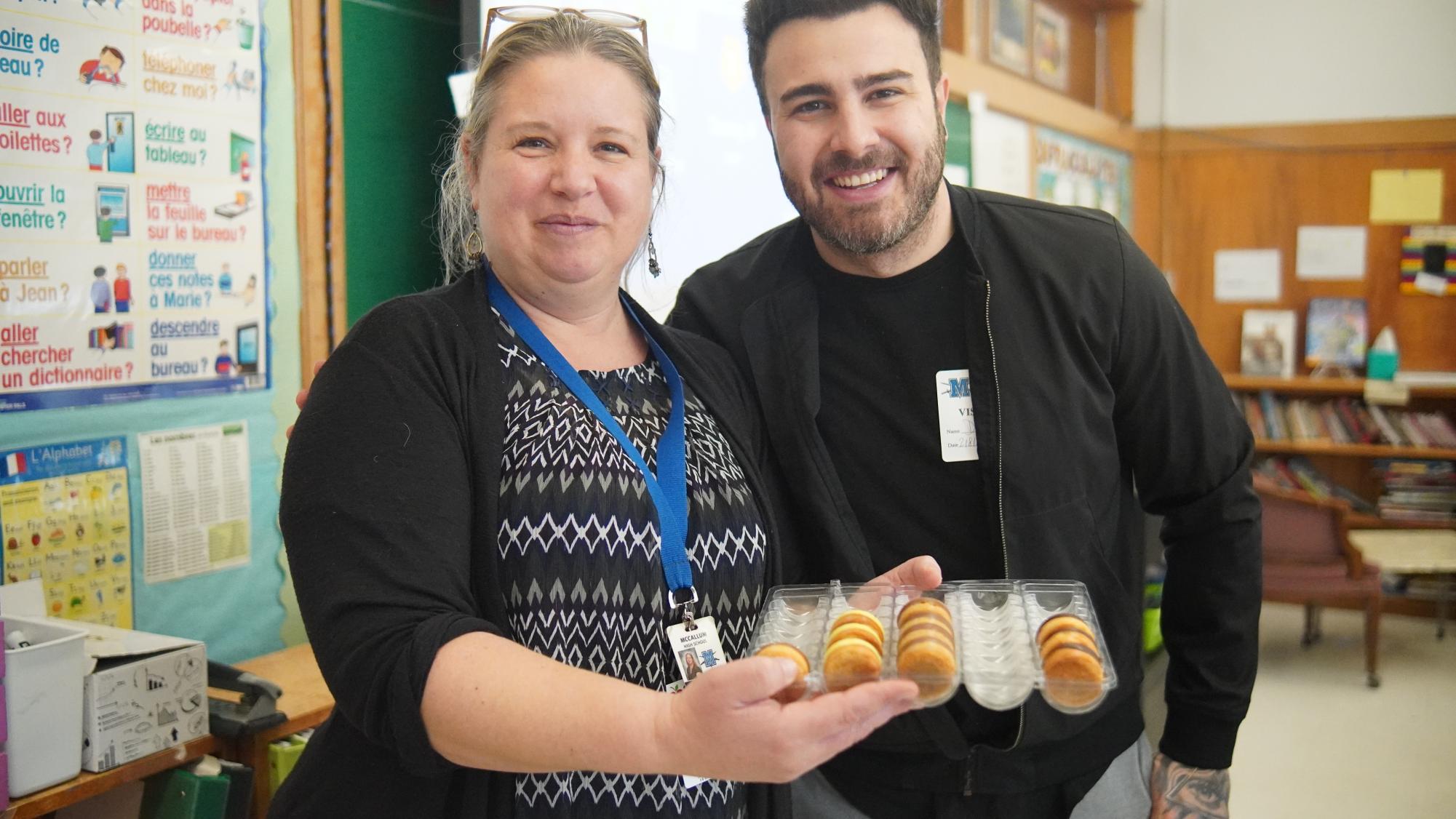 La professeure de français Charlotte Favrin et le chef invité Kevin dAndrea posent avec les délices desserts quil a apportés à la classe. La classe communiquait avec lui principalement en français.
