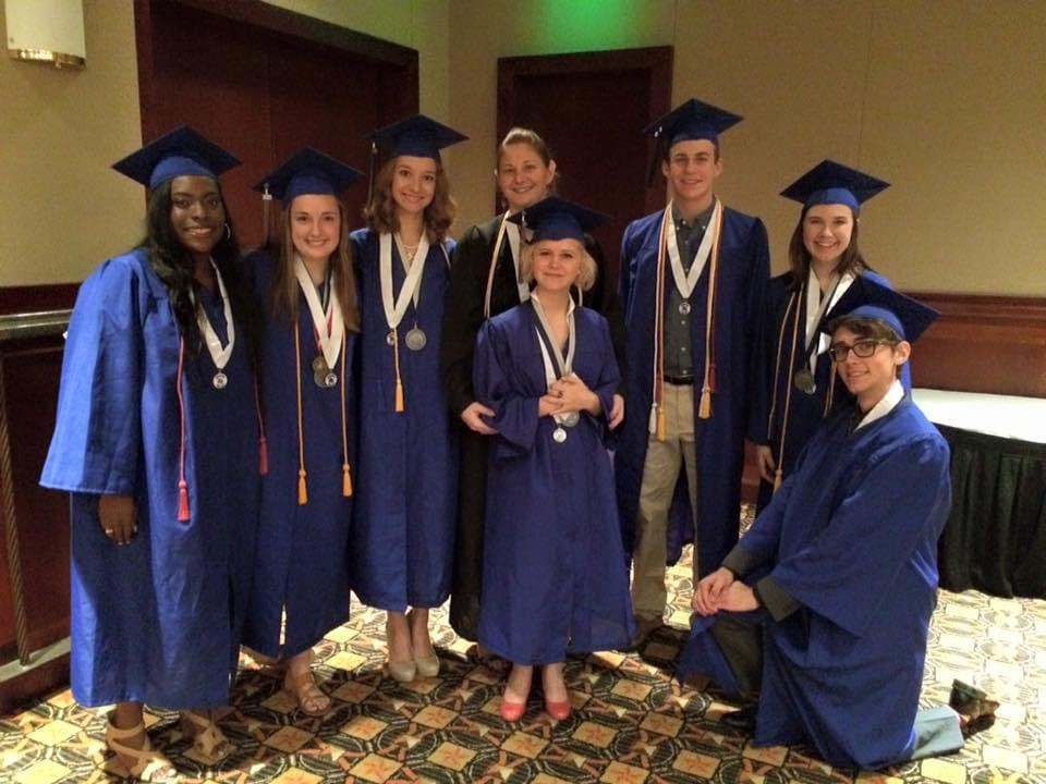 Amy Bujacz poses with her AP Biology students during McCallum graduation at the Frank Erwin Center in 2015.