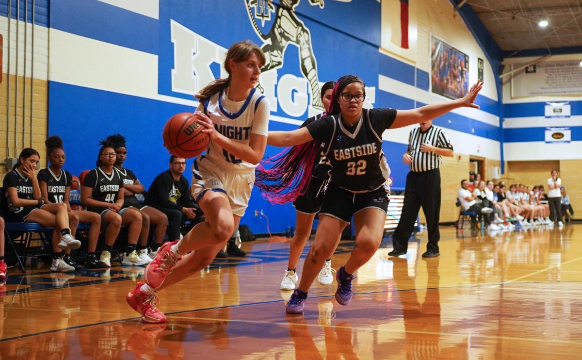 Freshman guard Ruby Airhart drives the baseline during the Knights 59-23 home win over Eastside. With several varsity players out sick, the team relied on younger players calling up several junior varsity players to play along Airhart and the other healthy varsity players able to suit up. 