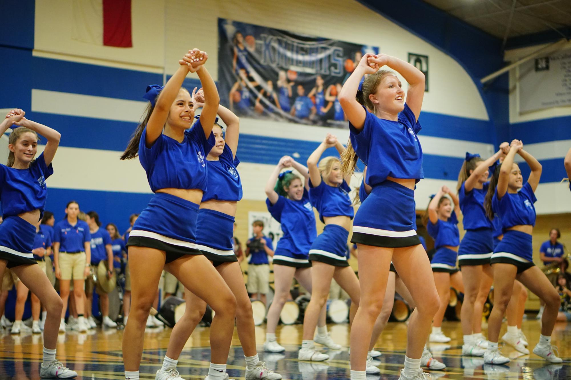 Senior captain Hannah Van Houten performs a routine with fellow cheerleaders during the pep rally before Taco Shack her junior year. Van Houten, pictured front, leads the routine. Caption and photo by Priya Thoppil.
