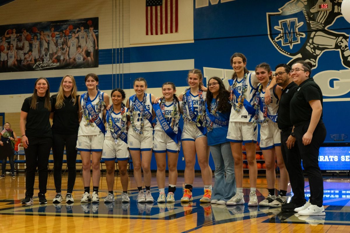 Elizabeth Miller poses with the other coaches and the seniors of the girls basketball program during senior night.