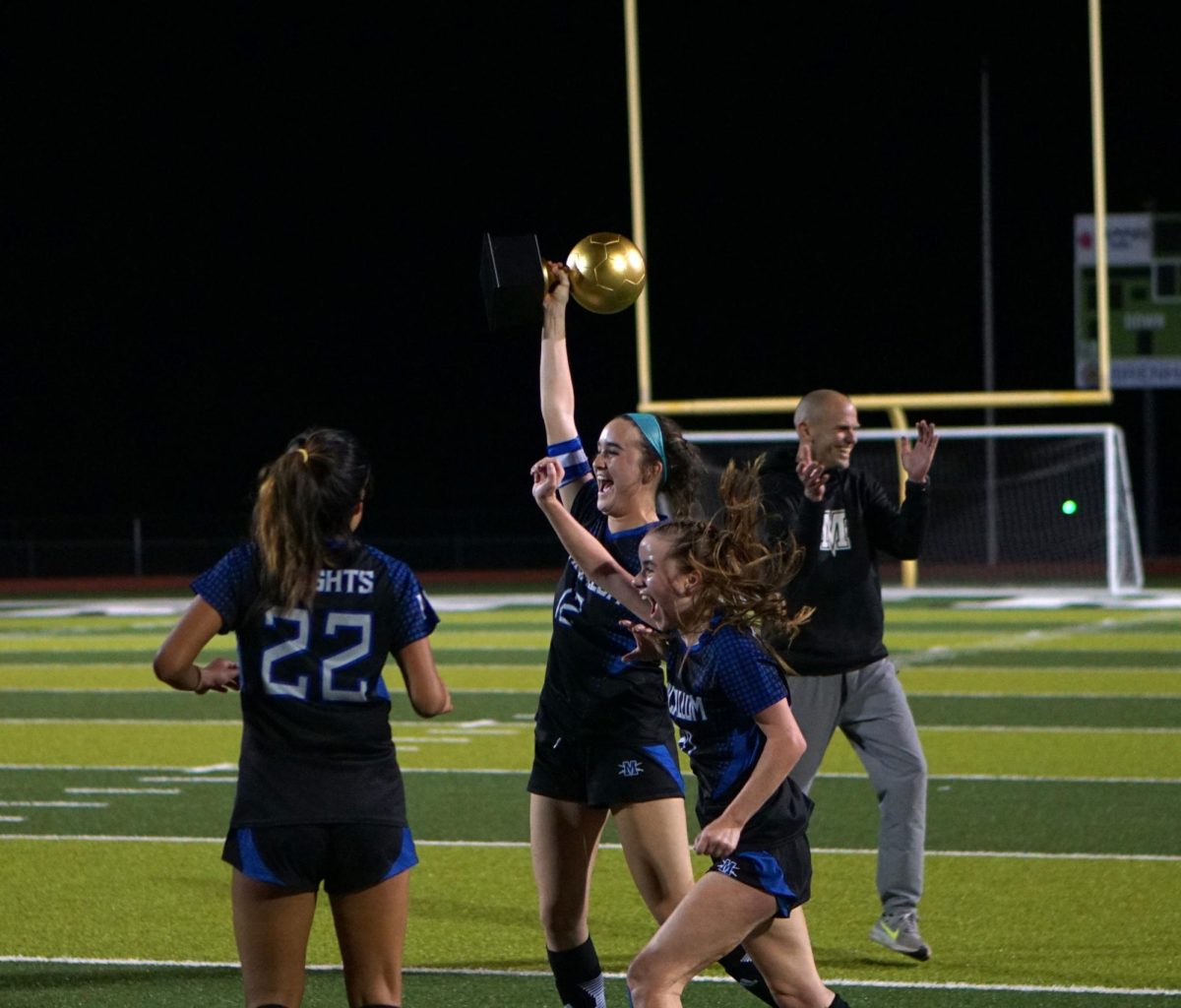 As head coach Thomas Gammerdinger claps for his team, defenders Isa Lopez Reed and Ruby Barnett flank Madi Briggs as she raises the area championship trophy before rushing to her teammates with it. Considering that Lopez Reed, Briggs, Barnett and Sienna Gunning anchored the back line throughout the game, the image seems like an apt symbol for how the game was won.