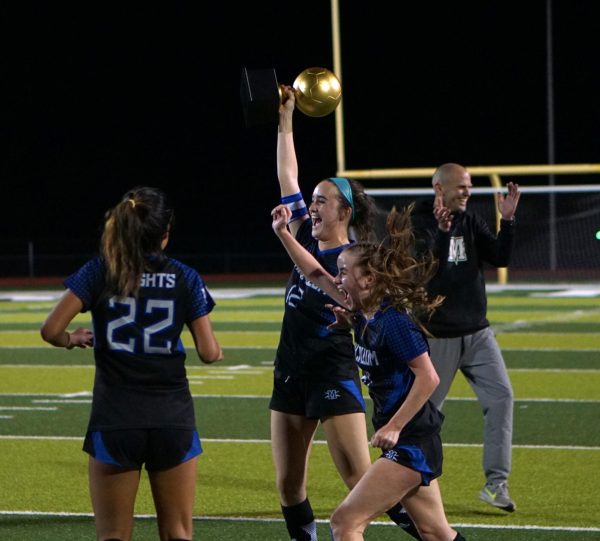 As head coach Thomas Gammerdinger claps for his team, defenders Isa Lopez Reed and Ruby Barnett flank Madi Briggs as she raises the area championship trophy before rushing to her teammates with it. Considering that Lopez Reed, Briggs, Barnett and Sienna Gunning anchored the back line throughout the game, the image seems like an apt symbol for how the game was won.