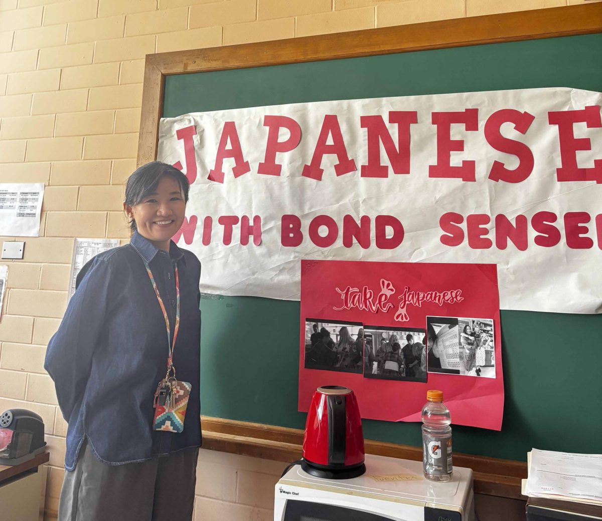 Bond Sensei, que se muestra aquí posando frente a su cartel para su clase de japonés, cree que las resoluciones son beneficiosas. Creo que es útil, dijo Bond. “Sin una meta no vas a ninguna parte; el objetivo es importante.”
