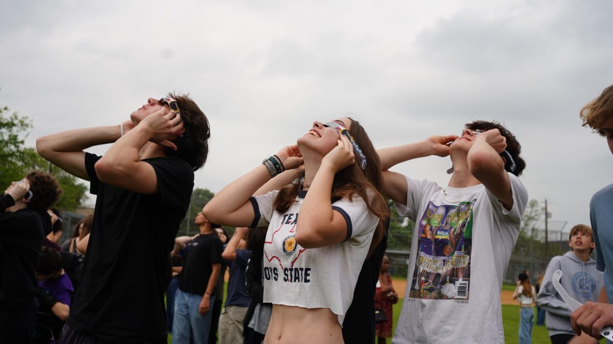 EXCLAIMING FOR THE ECLIPSE: Freshmen Jack Wood, Arwen Pelletier and Cole Truong watch the eclipse from the softball field with their digital media class. Pelletier said she was glad she chose to experience the eclipse with friends at school.

“So many kids were exclaiming whenever the clouds broke and you could actually see it,” Pelletier said. “I live really close, and my mom was at home and she was outside. She said that she could hear everyone yelling.”

For Pelletier, the highlight of the eclipse was the few seconds when the clouds parted and the eclipse was visible in totality.

“Ill always be able to remember what it looks like in my mind,” Pelletier said. “Some things I think about, but I cant remember what they looked like. But this was memorable enough and incredible enough that Ill be able to picture it forever.”

Caption by Ingrid Smith. 
