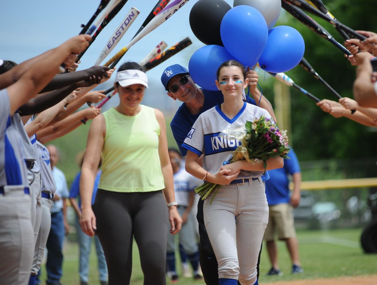 At the varsity softball team's Senior Night at April 13 at Butler Fields, senior Sadie Roselle and her parents walked through the tunnel formed by her teammates as a grand entrance prior to the first pitch.

The Knights celebrated the occasion by soundly defeating the Travis Rebels by a final score of 21-0. The Knights jumped on the Rebels early, scoring seven runs in the first inning then clinching their victory in the second inning 14 more. 

Going into the game, which was played at noon on a Saturday, the team was determined to win for the seniors. Despite the unusual game time for a senior “night,” the seniors’ teammates pulled out all the stops to celebrate the seniors for their hard work over the past season. They presented them  with gift baskets and cards. The team's defense, hitting and base running allowed them to prevail on the night that meant so much to them.

“I remember there was a lot of build up to the night,” senior Sadie Roselle said. “Everyone was spending a lot of time together beforehand. We were putting a lot of extra effort into our warmups and also having a good time and being silly and celebrating our last home game with the seniors before they went off to college.”

After the regular season-ending win against Travis, the team advanced to the 5A state playoffs as the No. 3 seed from District 24-5A. In the bi-district round of the playoffs on April 24, the Knights lost to Elgin by a final score of 11-2. 

Although the Knights lost, senior Sadie Roselle said she was proud of the team’s determination and consistent energy.

 “We were fighting from the beginning to the end,” Roselle said. “Even though we went five innings without scoring, instead of giving up in the sixth inning, we ended up scoring two runs.”

The Knights were the only District 24-5A team to avoid the dreaded run rule in their opening playoff game. 

“We were the only [5A] AISD [team] not to get run-ruled,” Roselle said, “which means that we were the only team not to lose by 15 runs. So for me that’s a win. We worked really hard to get to that point.”

Salinas said that being a part of the softball team has allowed her to develop and build friendships with teammates. 

“Softball for me is just a place where I can have fun and be with friends and make some memories,” Salinas said.

Roselle said that softball has been a constant for her throughout her four years of high school and that she has known many of her teammates since before freshman year.

“[Softball] has been a community for me,” Roselle said. “It’s been something I've been a part of and something I can always count on for a long time. So just the stability of being on the team and always having those people to support has been really meaningful.”
