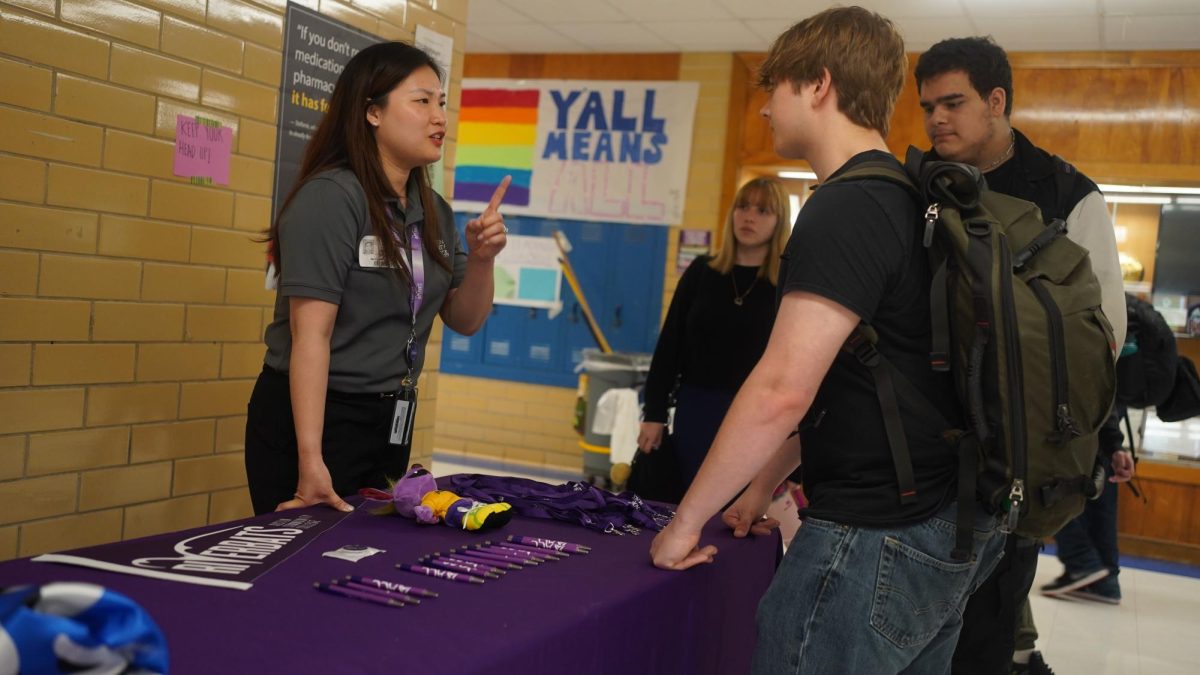 ACC recruiting specialist Nhi Tien speaks with students about the advantages of Austin Community College during the College Signing Day celebration in the main hallway during lunch on Friday.