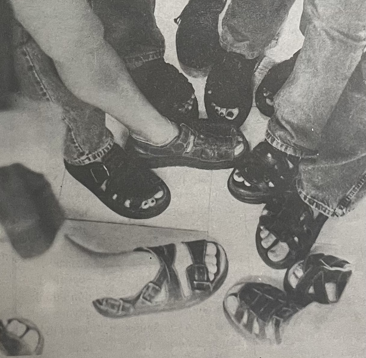 A gaggle of sophomores sport their Doc Marten sandals in the main hallway during lunch. Each pair carries a hefty price tag: at least $100 each. The sandals are popular among both boys and girls. For the first time, Doc Martens have made the full jump from grunge to prep. Caption by unknown student.