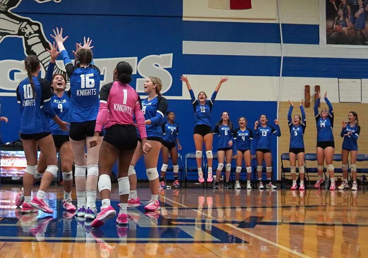 Surrounded by her teammates on the court and serenaded by the cheers of her teammates on the bench, junior setter Lexi Rosenblatt soaks in the moment immediately after senior outside hitter Greta Carlson's kill sealed the deal on Roseblatt's 1,000th assist as a McCallum Knight.