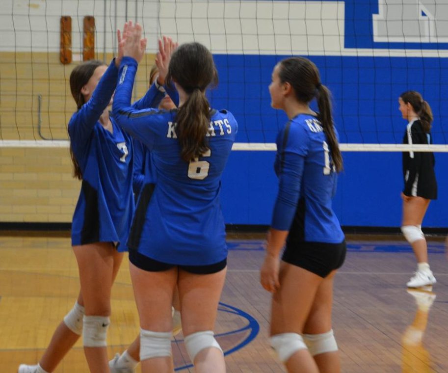 Freshman A teammates Lucy Tepera, Molly Bradfield and Grace Miller celebrate a point earned during the Knights victory over St. Andrew's in their first knockout round game of the Knight Freshman Volleyball Tournament. The Knights would go on to defeat LASA and Bowie to win the tournament for this first time in team history.